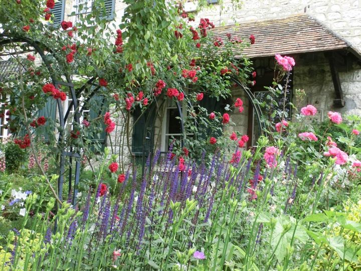 ほぼ放任のようにバラと宿根草が混じり咲いています。英仏でバラがきれいに決まるのは石壁やよろい戸といった構造のせいもあります。（筆者撮影）