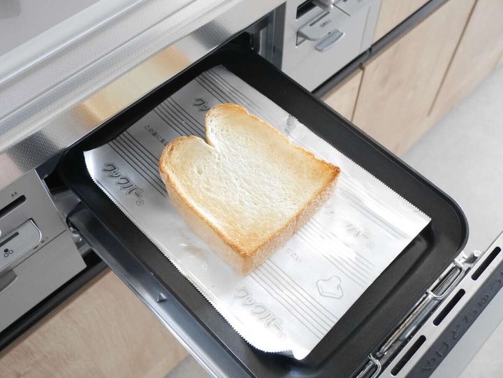 コンロのグリルトレイにクッキングシートを敷いて焼き上がった食パンが乗っている様子