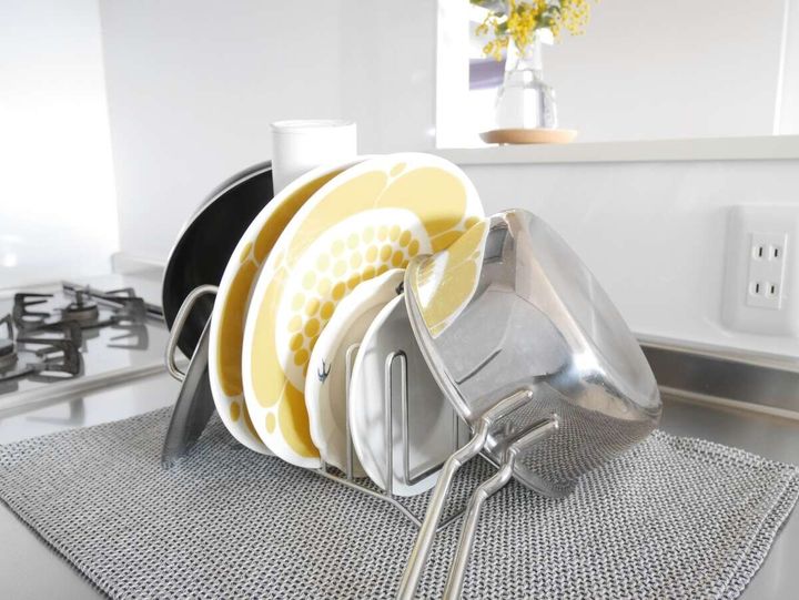 ティータオルの上にキッチンスタンドを置きお皿や鍋蓋を立てて乾かしているカウンターの様子