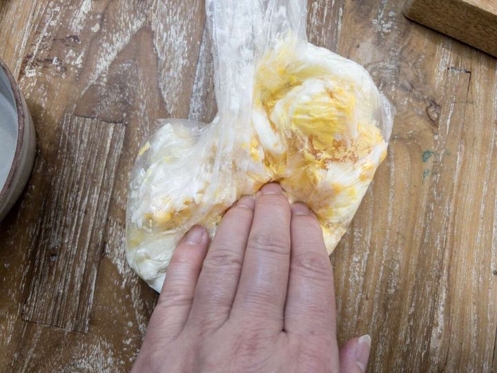 加熱後のアイラップを袋の外から手で揉んで卵をスクランブル状に砕いている工程写真
