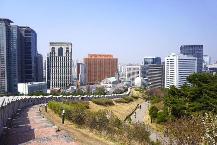 城壁のすぐ横を歩けるのは、韓国ならでは。オレンジのビルはドラマ「未生」のロケ地になった「ソウルスクエア」です。