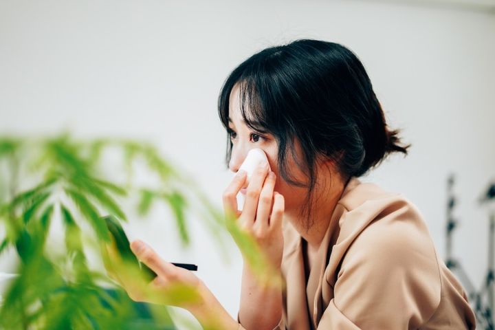 笑顔でメイクをする若い女性 メイク直し