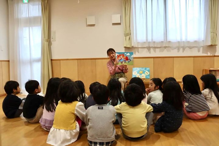 紙芝居「4つのパワーでつよいぞ！ムテキッズ」読み聞かせ。熱心に聞く園児たち