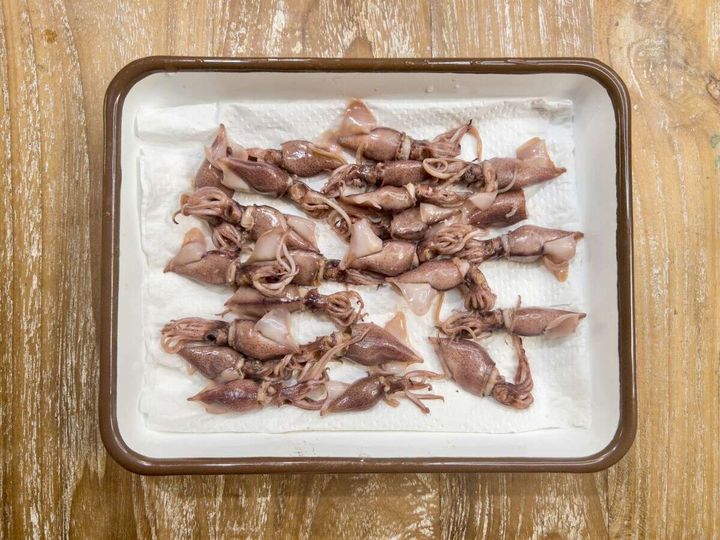 ボイルしたホタルイカをバットのキッチンペーパーに並べた下処理工程の俯瞰写真