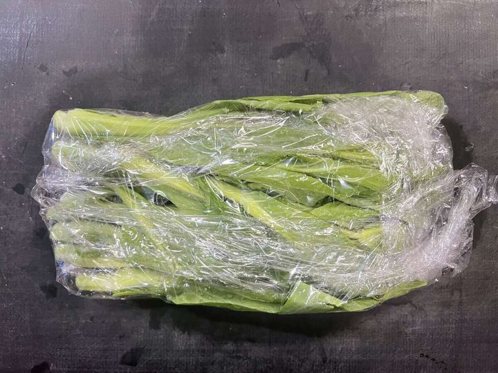 菜の花を濡れたままラップで包んだ電子レンジ加熱前の状態の俯瞰写真