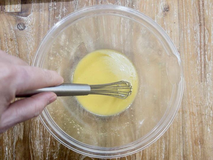 ガラスボウルの中のマリネ液をホイッパーで混ぜている工程の俯瞰写真