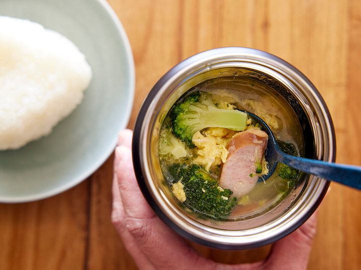 ソーセージと卵とブロッコリーのスープが入ったジャー、隣にはおにぎり