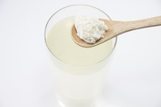 コップに入った麹水の上にスプーン1杯分の米麹