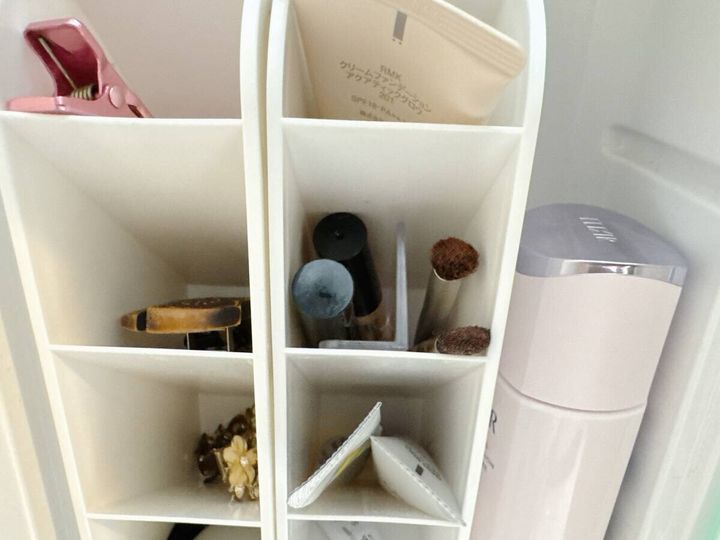 鏡裏収納でL字仕切り板を装着した白いスタンドにメイクブラシやヘアクリップが整理されている俯瞰写真