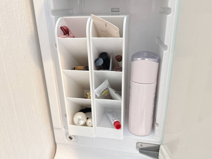 洗面台の鏡裏収納に白い仕切りスタンドを使いマスカラやリップなどメイク用品が整理されている