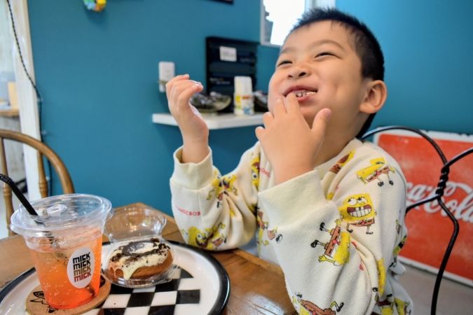 ドーナツを頬張る子ども