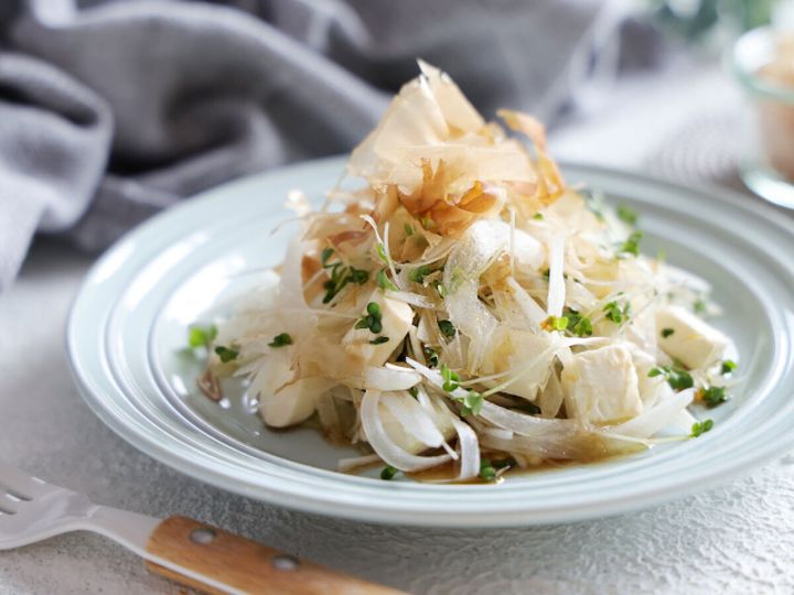 白い皿に盛り付けたおかかとクリームチーズの新玉ねぎサラダ