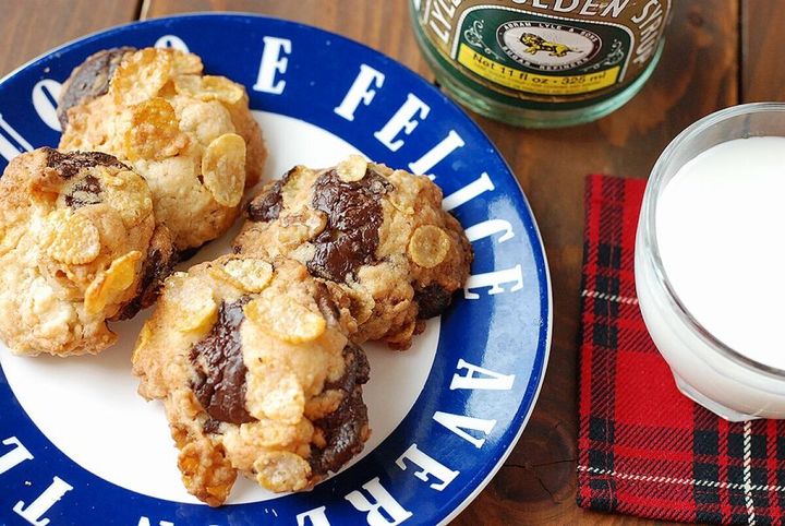 青い皿に盛られたコーンフレーク入りアメリカンクッキーと牛乳のグラス