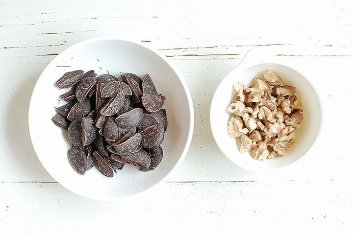 白い器に入れた粗く割ったビターチョコレートと小粒に割ったくるみ