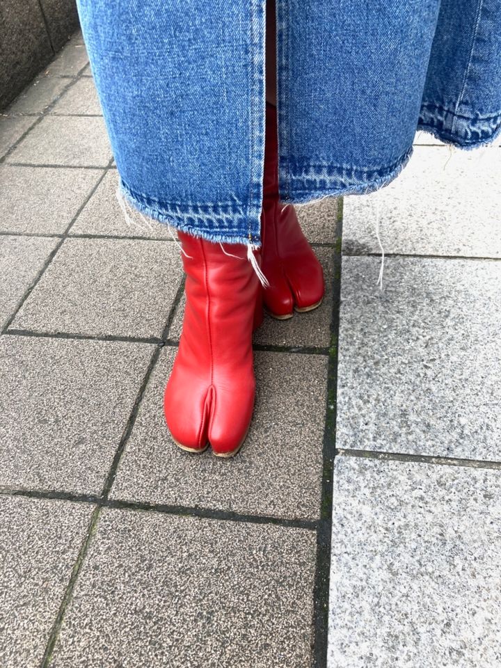 不動の人気を誇るメゾンマルジェラのタビブーツも赤でエッジを効かせて