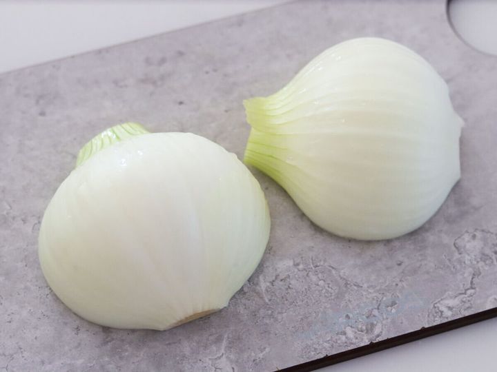 皮をむいて縦半分に切った新玉ねぎ