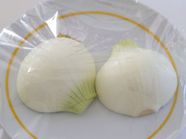 耐熱皿にラップをかけた半割りの新玉ねぎ