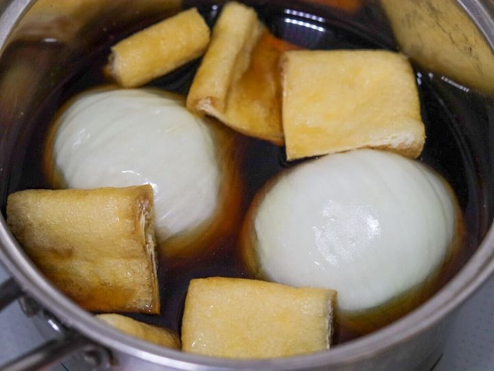 鍋に新玉ねぎと油揚げを入れて煮汁に浸した状態
