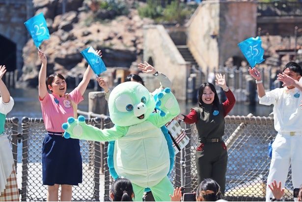 25周年のフラッグを持ったキャストと一緒に、セレブレーションダンスを踊るオル・メル