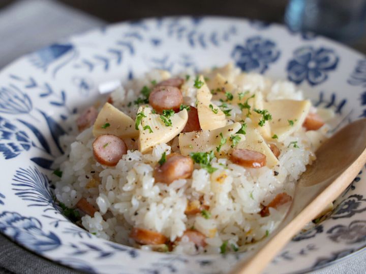 青い花柄の皿に盛ったたけのことソーセージの白だしピラフ完成品