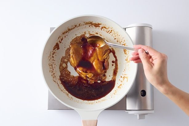 鶏肉にたれをスプーンで回しかけながら煮詰める。少しとろみがついたらOK！ （C）こぴ／KADOKAWA