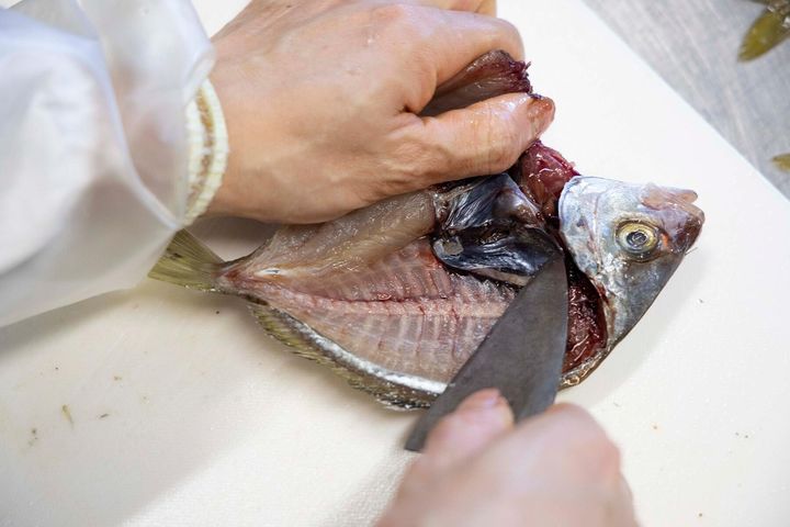 手と包丁で身を押し開く