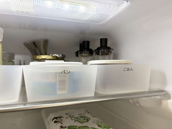 冷蔵庫の中に「パン」「ごはん」とラベルを貼った半透明の収納ケースが並ぶ様子