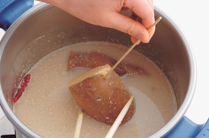 竹串を刺して硬さチェックしているたけのこ