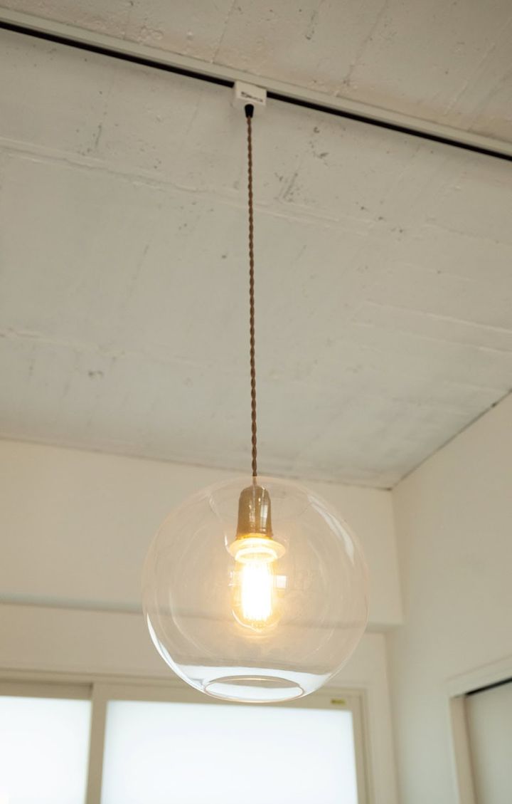 寝室の照明は、KANADEMONOのもの。存在感のあるガラスシェードに注目