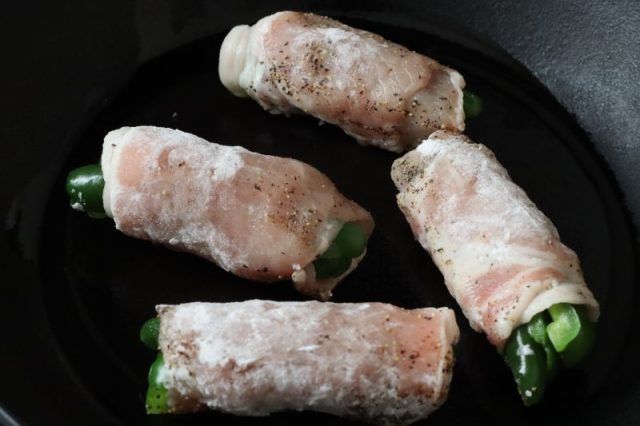 フライパンに並べたピーマンの肉巻き