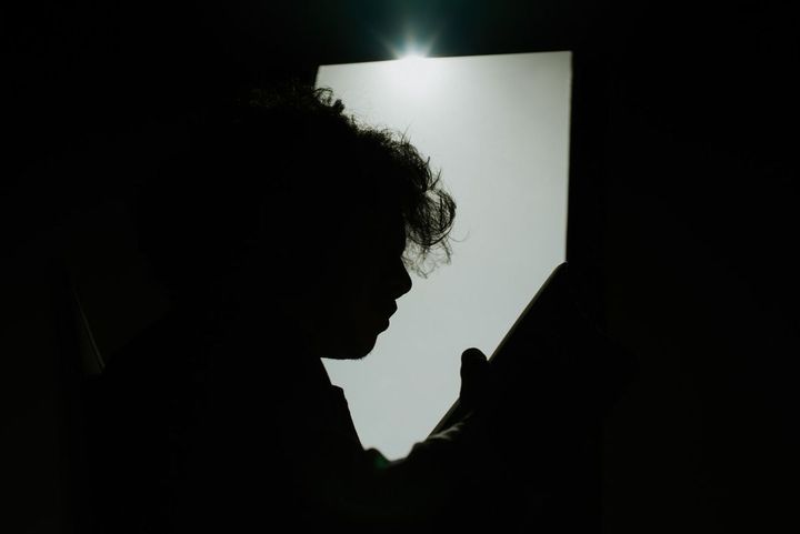 暗がりで本を読む男性