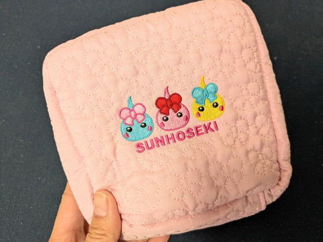 ほっぺちゃんキルティングポーチの正面。3キャラクターの刺繍とSUNHOSEKIロゴ