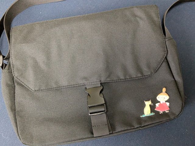 ムーミン公式ファンブック2026付録のショルダーバッグ全体。ブラックのボディにバックル留めのフラップがついている