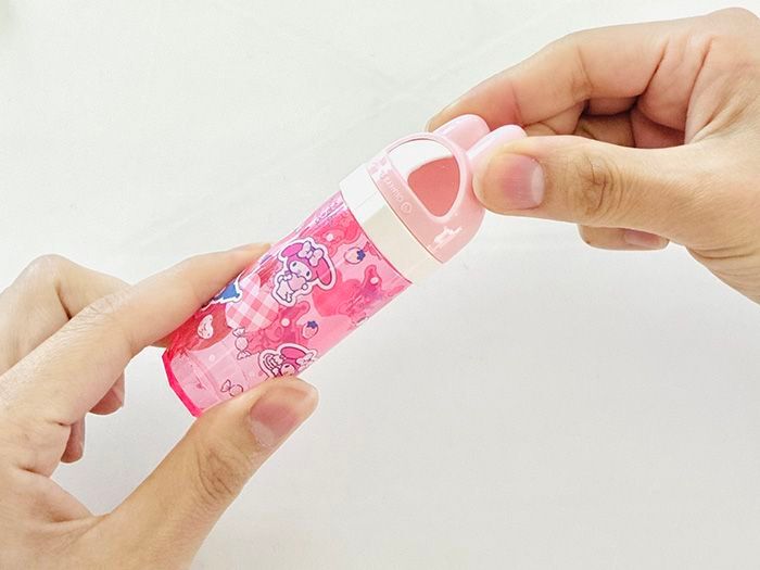 マイメロディ柄の携帯用綿棒ケースのフタを開けている