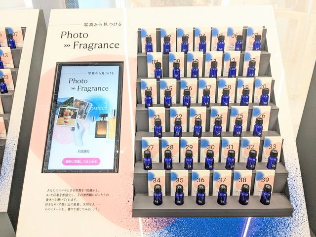 Photo→Fragranceの端末画面と、番号1〜39まで並ぶ青いサンプルボトルのコーナー