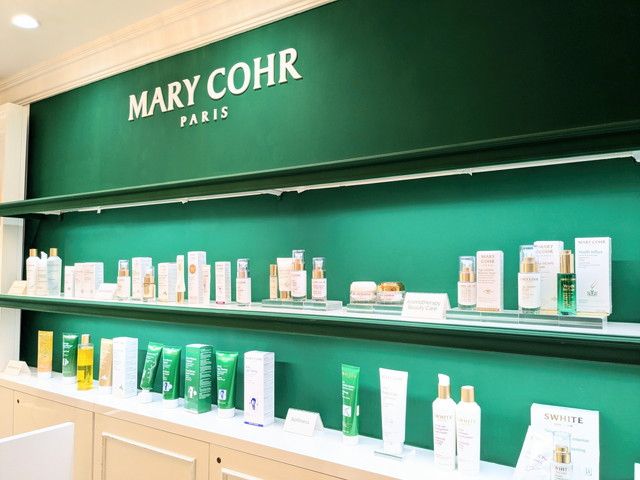 マリコール 伊勢丹新宿店の店内。グリーンの壁面にスキンケア商品がずらりと並んでいる