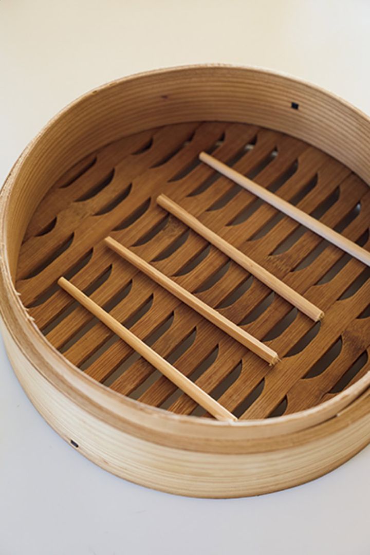 割り箸の上に耐熱皿をのせると、蒸気が対流して火が入りやすくなる。