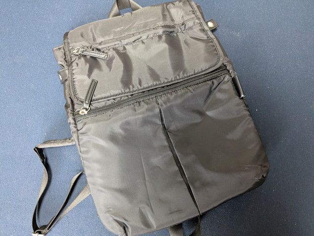 Y'SACCSデイリーリュック前面全体。上部にフラップポケット、中央にファスナーポケット、下部に2つのスリットポケットがある