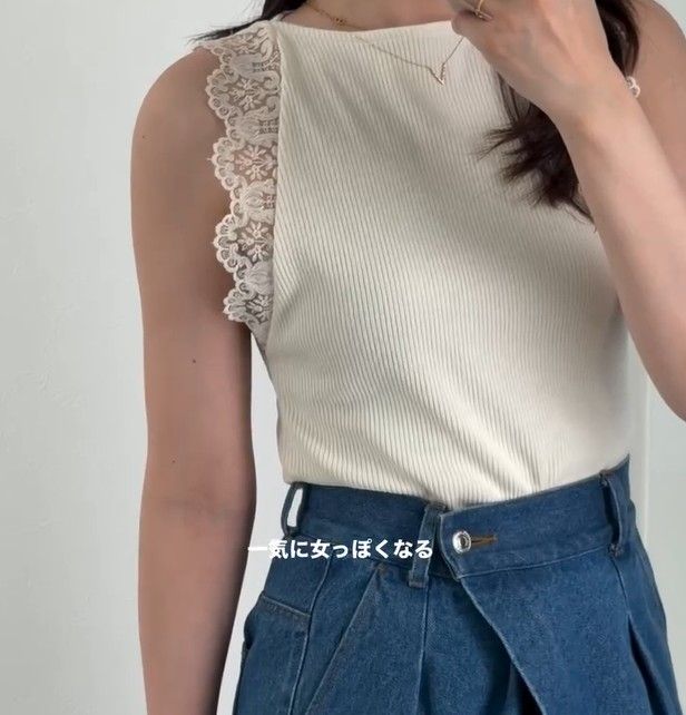 クリームカラーのリブノースリーブトップス。両サイドに繊細なレーストリムがあしらわれ、デニムワイドパンツと合わせたコーデ