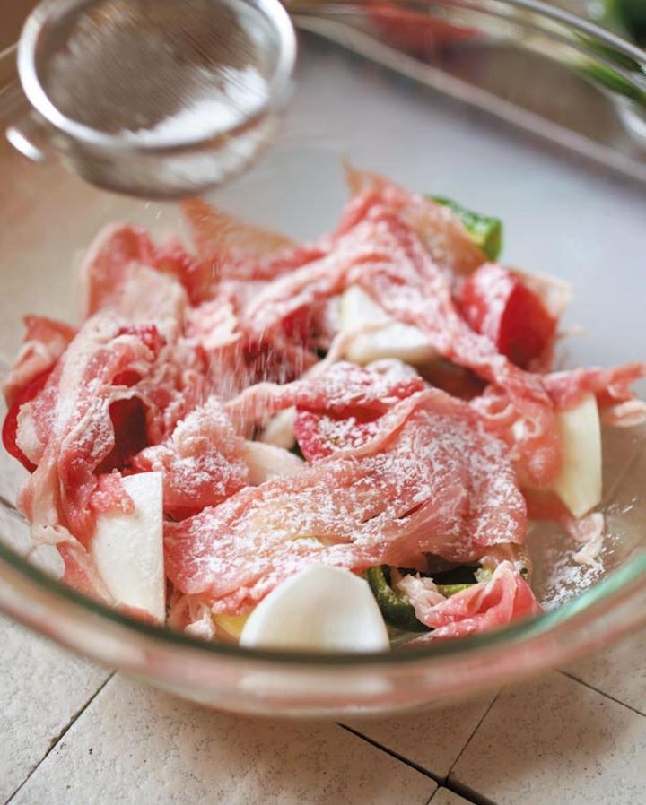 （b）豚肉をのせたら塩、こしょうをし、片栗粉は茶こしでまんべなくふる。