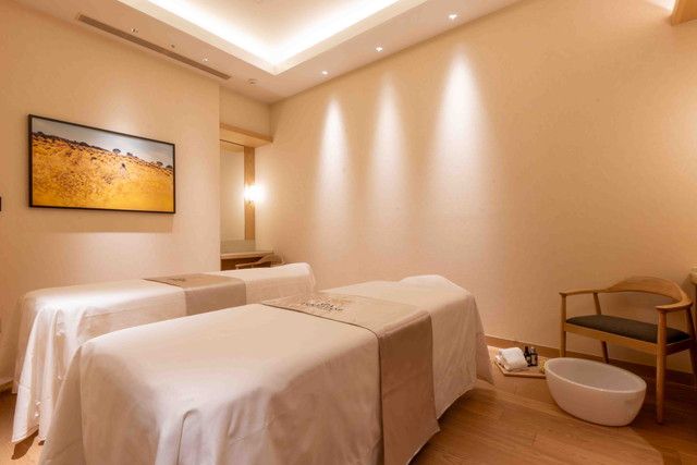 SPA L'OCCITANE EN PROVENCEのイモーテルルーム。2名用のトリートメントベッドが並ぶ温かみのある空間