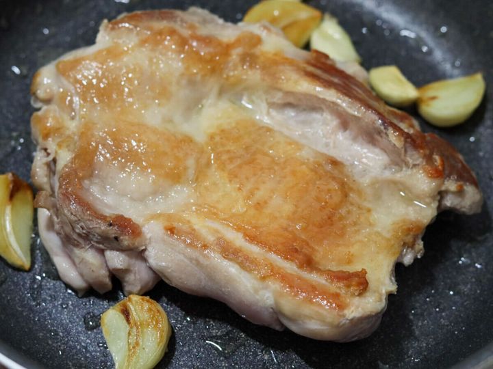 皮がきつね色にパリッと焼けた鶏もも肉と焼いたにんにく