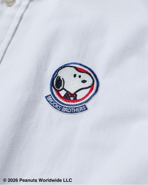 左胸には、紺ブレザーと赤いボウタイでドレスアップしたスヌーピーのエンブレム風刺しゅうを配置