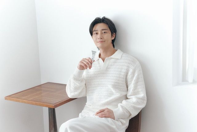 パク・ソジュンが白ニット姿でmeet treeのチューブ製品を持ちリラックスしている未公開カット