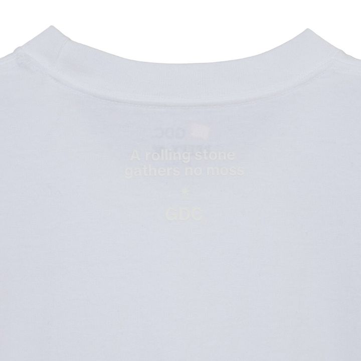 デザインはフロント胸元にGDCロゴ、背面ネックポイントに“A rolling stone gathers no moss”のレターグラフィックを配置。ミニマルな表情の中に、しっかりとメッセージを込めた一枚に。