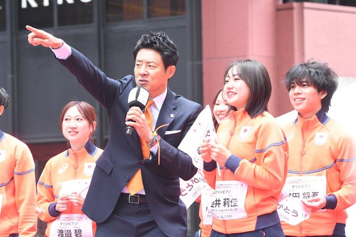 画像: 「松岡さんの大ファン」とカミングアウトし、緊張した様子の金井莉佳選手（スケートショートトラック）に、「TEAM JAPANコール」のアドバイスをする松岡氏。