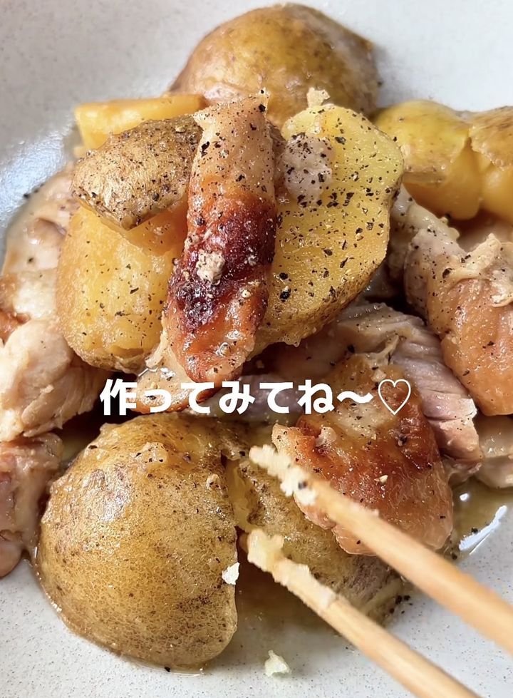 Bowl of roasted potatoes with crispy skins and chunks of meat; chopsticks lifting a piece for a bite, with a casual food photo vibe.