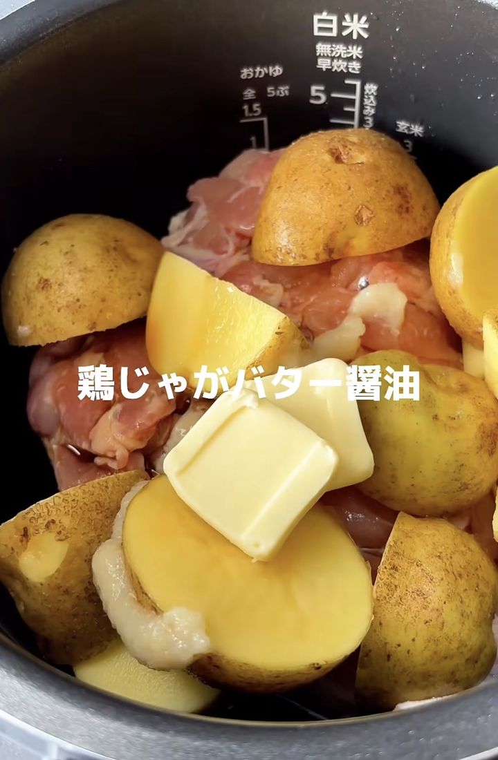 Chicken and potato pieces arranged in a pot with a knob of butter, ready for soy sauce cooking (text in Japanese overlay).