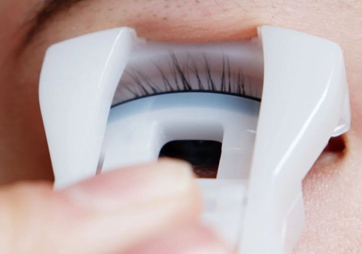 コンパクトビューラーでまつ毛をカールさせる様子