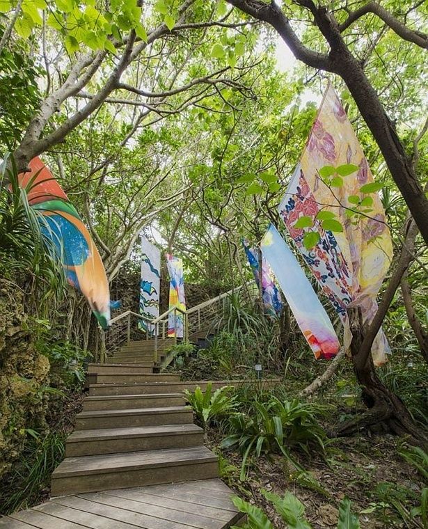 波に削られた奇岩と亜熱帯地域特有の植物が生い茂る「岩場のテラス」では、無数のタープを飾る「アートなそよ風」が登場！思わずお昼寝したくなるほど居心地がいい場所だ